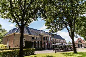 a building with trees in front of it at Stadspaleis Hotel & Restaurant OldRuitenborgh in Vollenhove