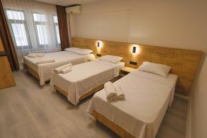 a hotel room with three beds in a room at Doruk Pansiyon in Amasra