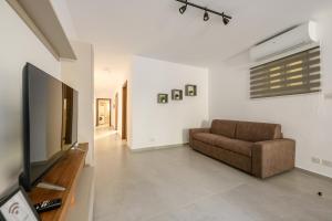 a living room with a couch and a flat screen tv at F41 Private room ensuite shared flat in Il-Gżira