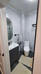 a bathroom with a toilet and a sink and a mirror at Квартира in Cholpon-Ata