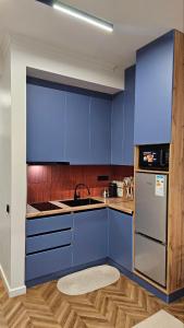 a kitchen with blue cabinets and a sink at Квартира in Cholpon-Ata