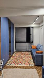 a living room with a blue couch and a rug at Квартира in Cholpon-Ata