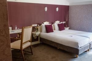 a hotel room with a large bed and a chair at Stadspaleis Hotel & Restaurant OldRuitenborgh in Vollenhove