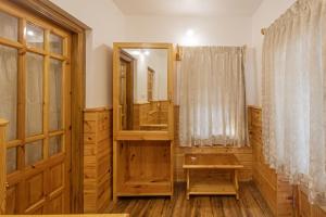 a wooden bathroom with a mirror and a dressing room at Lilly's Valley Resort in Kodaikānāl +291 photos