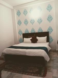 a bedroom with a bed with blue and white wallpaper at Sandhya Guest House Varanasi Near Ganga River in Varanasi +9 photos