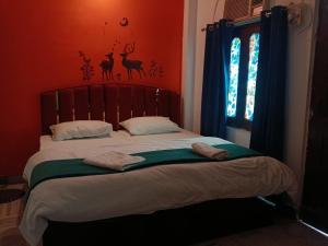 a bed with two towels on it in a bedroom at Sandhya Guest House Varanasi Near Ganga River in Varanasi