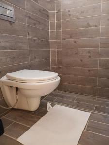 a bathroom with a toilet and a tile wall at Le Jardin Aparthotel in Taza +76 photos