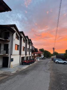 an empty street with cars parked in front of buildings at Pensiunea Mirela Bears Cave in Chişcău +22 photos