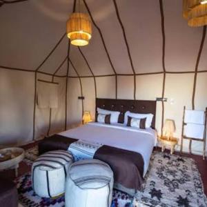 a bedroom with a large bed in a tent at Best-Merzouga traditional camps in Merzouga