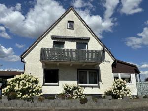 a white house with a balcony on top of it at Ferienwohnung Sonnenschein mit Balkon in Lage