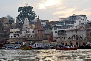 a group of boats in the water near a city at Sandhya Guest House Varanasi Near Ganga River in Varanasi