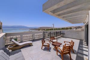 a balcony with chairs and a view of the ocean at זוהר על הים - ווילה ו-3 חדרי סטודיו מהממים עם בריכה בנווה זוהר in Neve Zohar