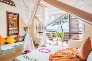 a bedroom with a bed with a view of the ocean at Sunshine Marine Lodge in Matemwe