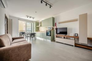 a living room with a couch and a kitchen at GZR F51 Bedroom in Penthouse in Il-Gżira