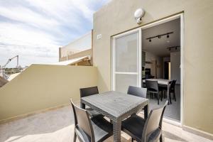 a patio with a table and chairs on a balcony at GZR F51 Bedroom in Penthouse in Il-Gżira