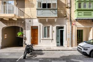 a bike parked in a parking lot in front of a building at GZIRA F52 Bedroom in pethouse in Il-Gżira