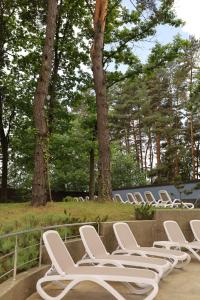 a row of white lounge chairs sitting on a deck at Kryve Ozero in Novoyavorivsk +95 photos