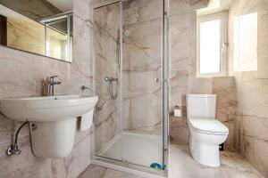 a bathroom with a toilet and a sink and a shower at GZIRA F52 Bedroom in pethouse in Il-Gżira +9 photos