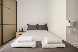 a bedroom with a white bed with two white pillows at GZIRA F52 Bedroom in pethouse in Il-Gżira