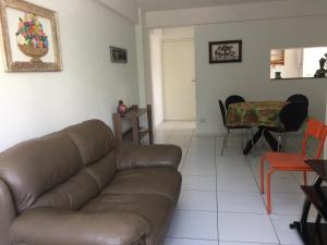 sala de estar con sofá marrón y mesa en Apartamento Ametista 6, en Maceió