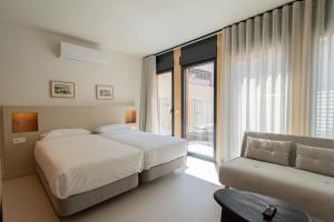 a hotel room with a bed and a couch at Edificio Ferrari 4, by Plaza Mayor Apartamentos in Valladolid