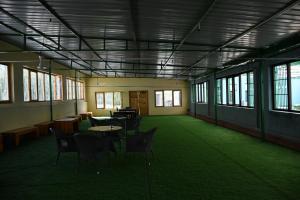 an empty room with chairs and tables and windows at Blue Yak Resort in She +26 photos