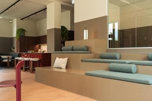 a waiting area with blue seats and a chair at Habyt Vienna in Vienna