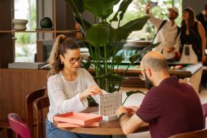 a man and a woman sitting at a table with a box at Habyt Vienna in Vienna