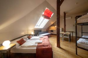 a bedroom with two beds and a loft with a window at Czech Inn in Prague +80 photos