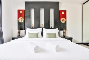 a bedroom with a large bed with white sheets and pillows at Pool Villa Pattaya Jomtien Beach - Palm Oasis C4 in Jomtien Beach +16 photos