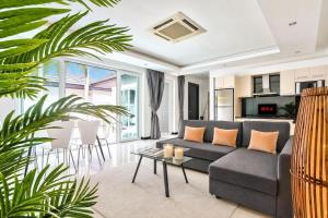 a living room with a couch and a table at Pool Villa Pattaya Jomtien Beach - Palm Oasis C4 in Jomtien Beach