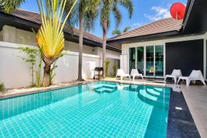 a swimming pool in the backyard of a villa at Pool Villa Pattaya Jomtien Beach - Palm Oasis C4 in Jomtien Beach