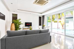a living room with a couch and a tv at Pool Villa Pattaya Jomtien Beach - Palm Oasis C4 in Jomtien Beach