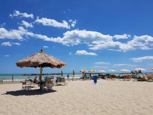 a beach with tables and chairs and umbrellas and the ocean at Mare e Tulipani in Porto San Giorgio +3 photos