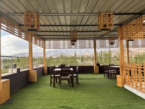 a dining room with tables and chairs and mountains in the background at Blue Yak Resort in She
