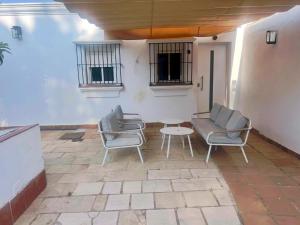 a patio with two chairs and a table at Casa Playa La Barrosa in Novo Sancti Petri