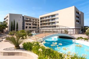 a bridge over a swimming pool in front of a building at Hotel Garden Istra Plava Laguna in Umag