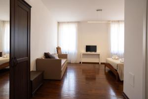 a living room with a couch and a tv at Il Grottino Relais & Spa in Gualdo Cattaneo