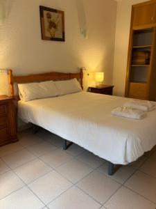 a bedroom with a bed with a white bedspread at Apartaments Els Avets in Pas de la Casa