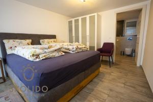 a bedroom with a bed with a purple comforter at Casa Sunegga in Naters