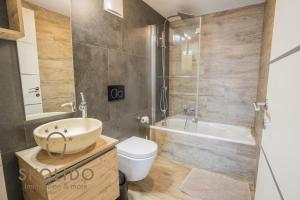 a bathroom with a sink and a toilet and a tub at Casa Sunegga in Naters +8 photos