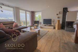 a living room with a couch and a tv at Casa Sunegga in Naters