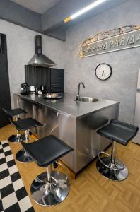 a kitchen with a sink and four bar stools at jim villa1 family apartment fast wi-fi free parking in Kyllini +25 photos