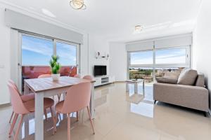 a dining room with a table and chairs and a couch at Aparthotel Laguna Rosa in Los Montesinos