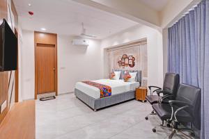 a hotel room with a bed and a desk and chairs at FabHotel Royal Midway in Gandhinagar
