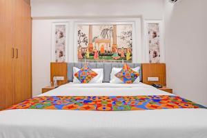 a bedroom with a large bed with a colorful blanket at FabHotel Royal Midway in Gandhinagar +20 photos