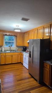 a kitchen with wooden cabinets and a stainless steel refrigerator at White Squirrel Cottage in Crawfordville