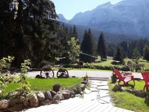 a garden with red chairs and a view of a mountain at chambre pour 2 à 4 personnes ,balcon in Mont-Saxonnex +10 photos