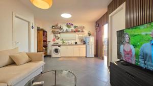 a living room with a couch and a flat screen tv at BOND Grand Suites in Beer Sheva