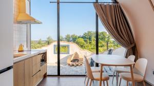 a kitchen with a table and chairs and a large window at Ganghwa Aiem Glamping in Incheon